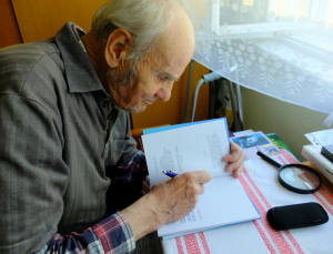 Š. Meliš pri písaní venovania knihy o povestiach autorovi rozhovoru (foto: M. Furman 2017)